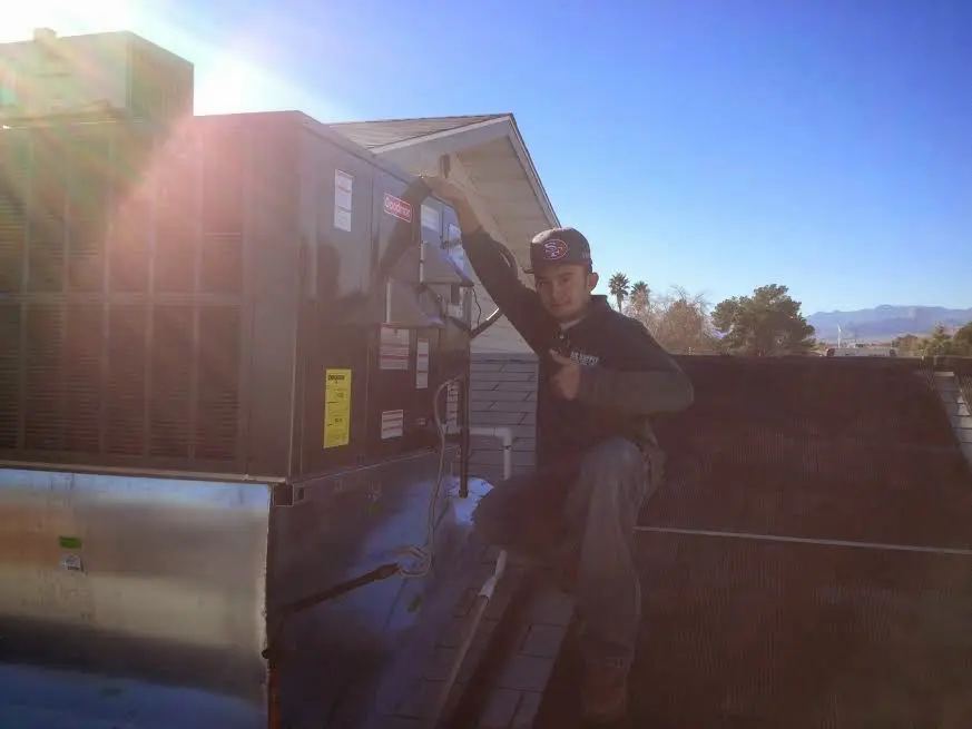 HVAC technician performing Boiler Repair on a rooftop unit in Terrell